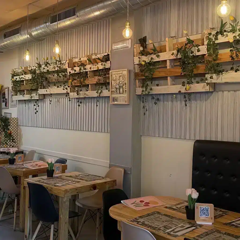 Interior de Bistro Bar Los Tulipanes con mesas de madera y decoración acogedora en Sevilla.
