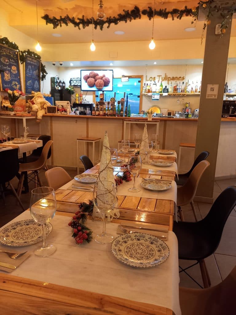 Cena de Navidad en Sevilla en Bistro Los Tulipanes con mesas elegantemente decoradas para una velada festiva y acogedora.