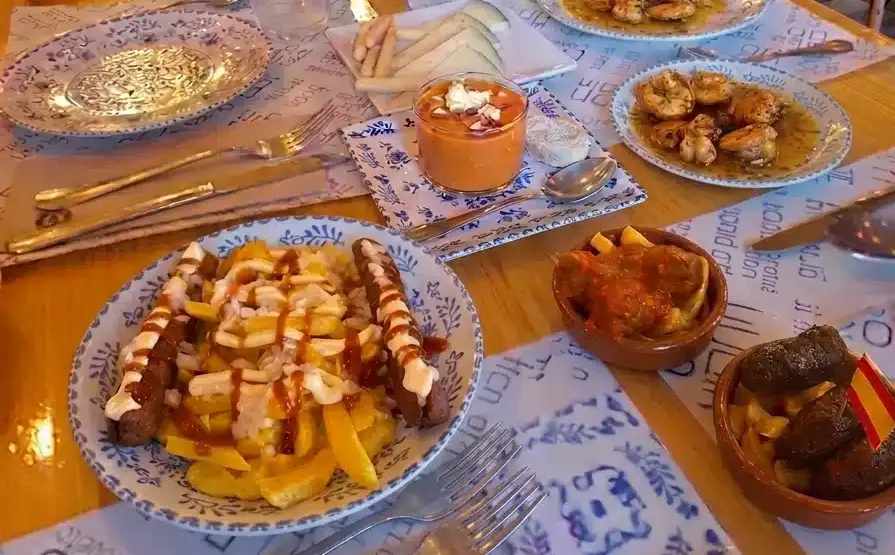 Grupo de personas disfrutando de una comida con carne a la parrilla. Buenos restaurantes en Sevilla.